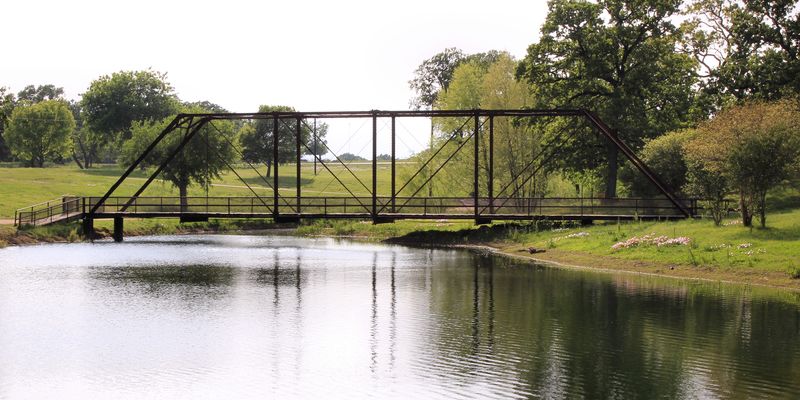 An iron bridge over the pond at Wilson Ledbetter Park in Cameron