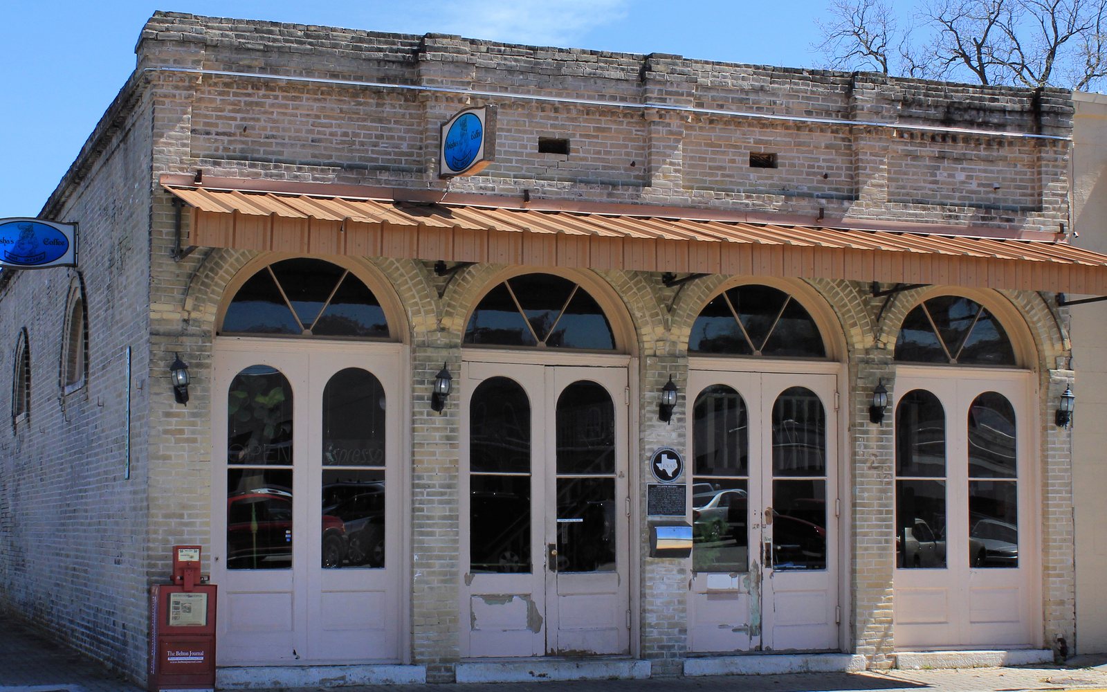 An old stone storefront with arched windows in downtown Belton