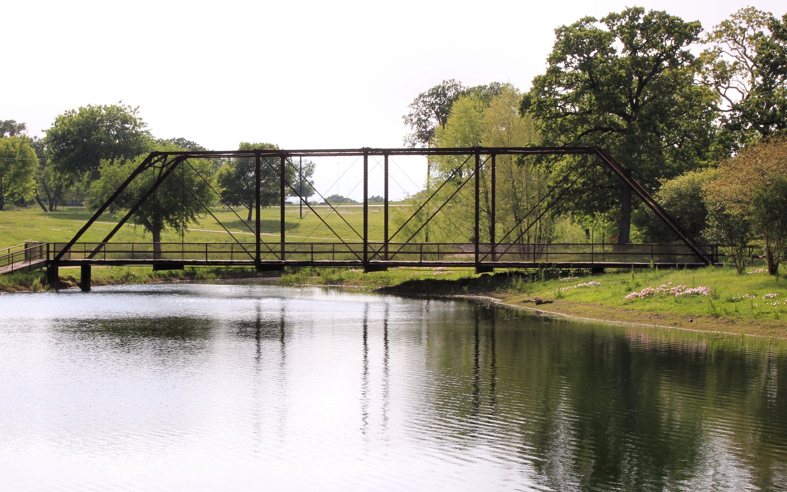 An iron truss bridge over a pond at Wilson-Ledbetter Park