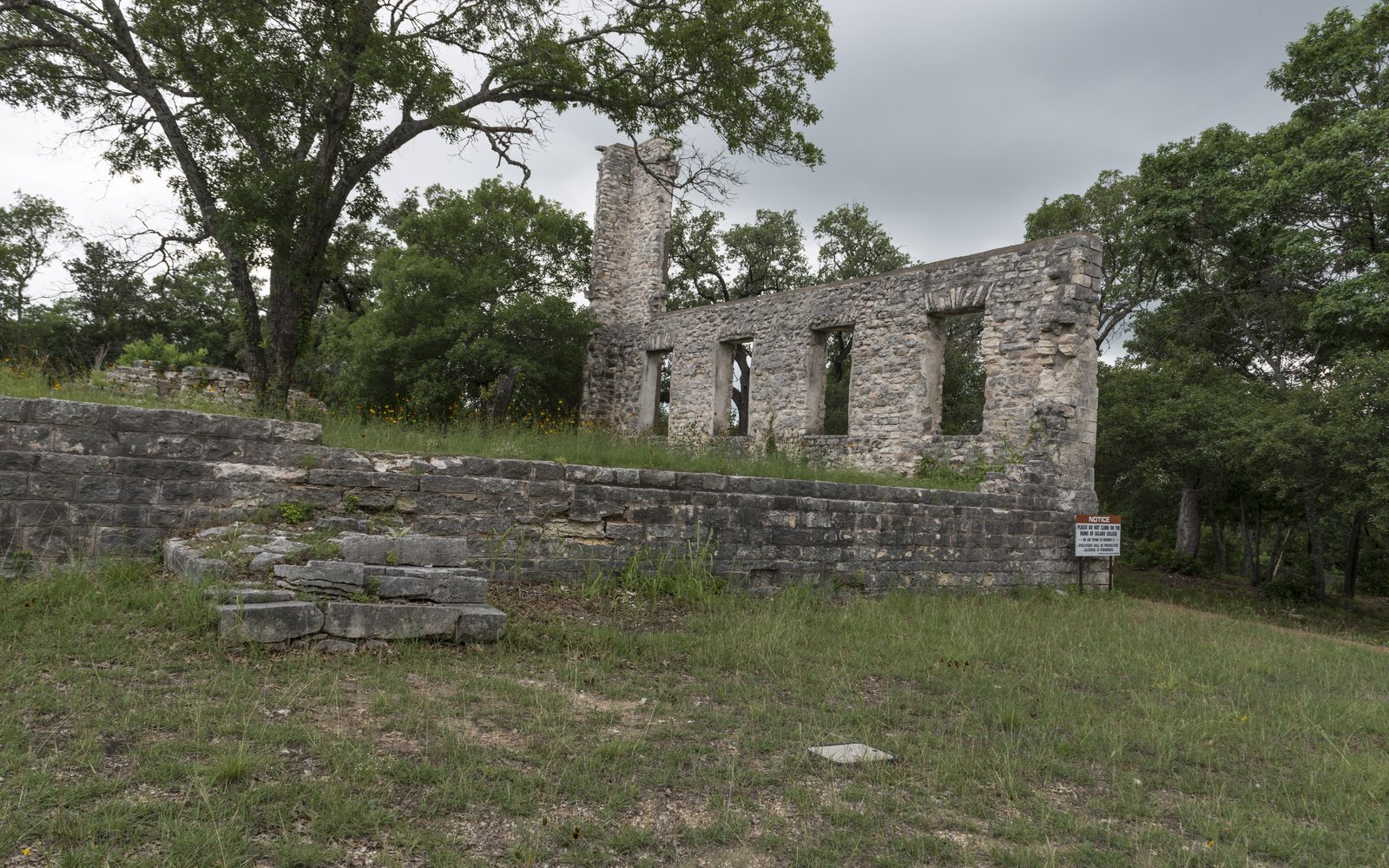 Stone ruins of Salado College under oak trees
