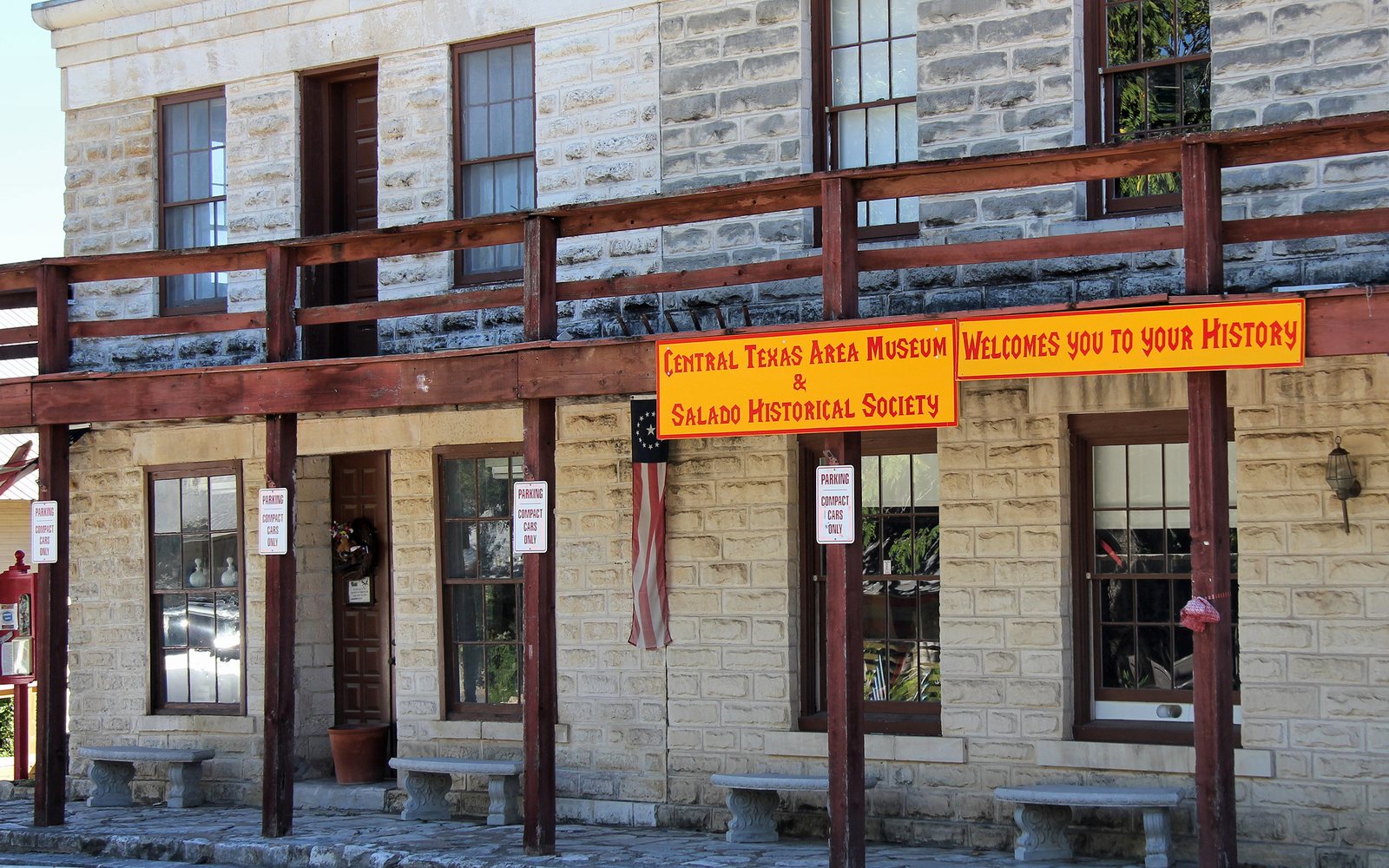 A two-story stone building with a wooden balcony in Salado