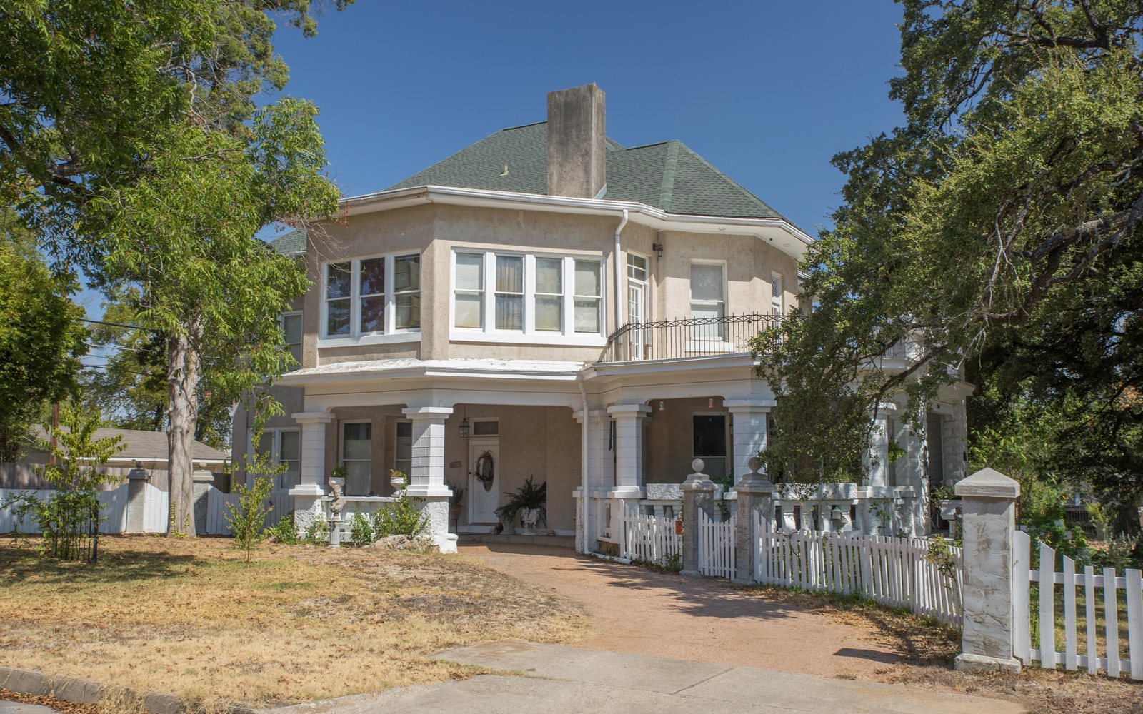 A historic two-story house with a wide porch in Temple