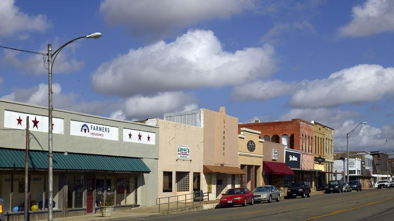 A street of old storefronts in downtown Moody under a big sky