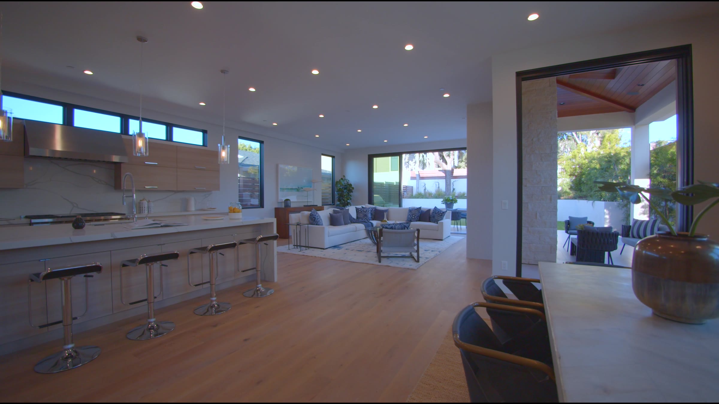 A bright kitchen opening onto a living room and patio