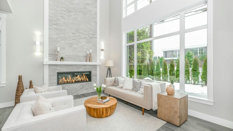 A bright living room with a fireplace and tall windows